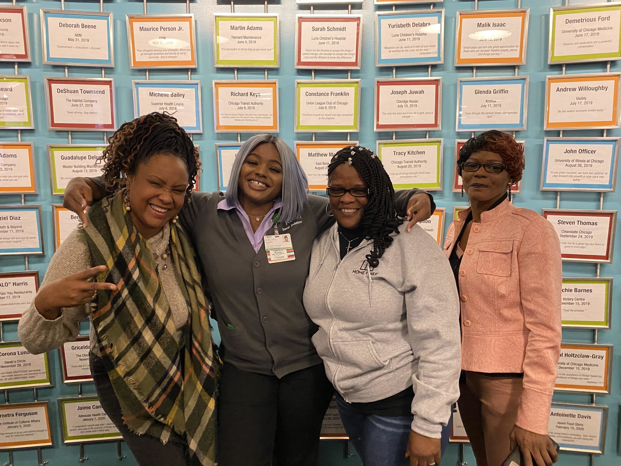 Participants celebrating career milestones in front of Cara's Great Wall