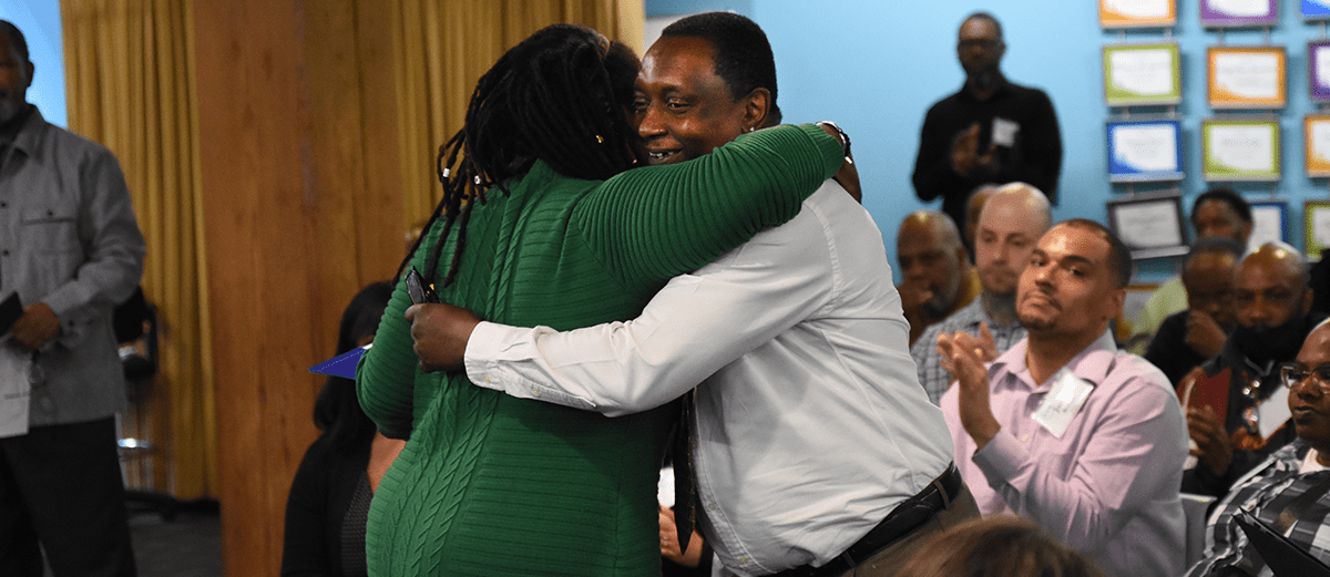 Photo of Cara job seeker, Otha, hugging Cara staff.